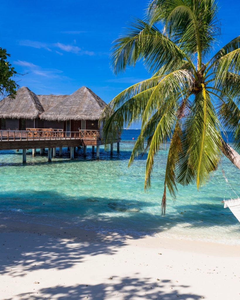 Luxury tropical beach resort with turquoise lagoon and palm trees, inspiring a dream holiday destination.