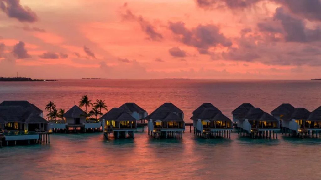 Luxury tropical destination with overwater villas at sunset